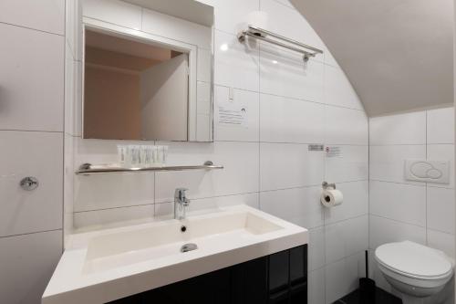 阿姆斯特丹Midtown Hotel Triple Room的白色的浴室设有水槽和卫生间。