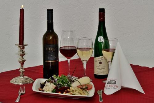 GraachWeinhaus Hotel zum Josefshof的一张桌子,上面放着两瓶葡萄酒和一盘食物