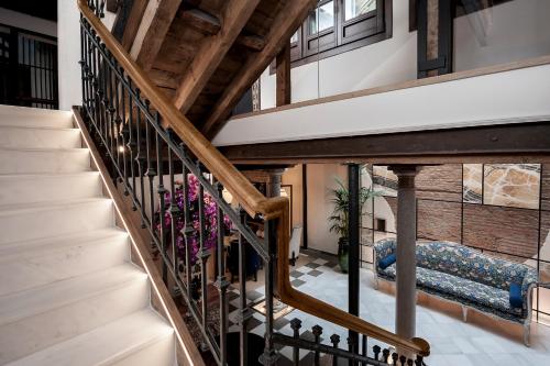 格拉纳达Hotel Casa Palacete Tablas的房屋内的楼梯,设有木制天花板