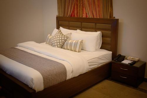 卡拉奇Xefan Hotels的一张带白色床单和枕头的床