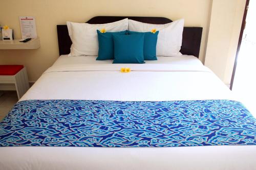 TjakranegaraDjembank Hotel的一张带蓝色和白色床单及枕头的床