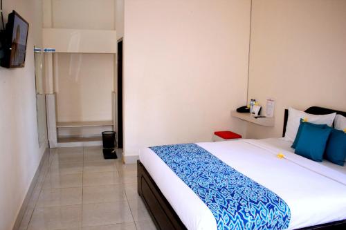 TjakranegaraDjembank Hotel的一间卧室配有一张带蓝白色床单的大床