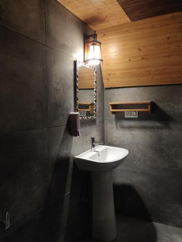 卡索尔La Familia Kasol的浴室配有水槽和墙上的灯。