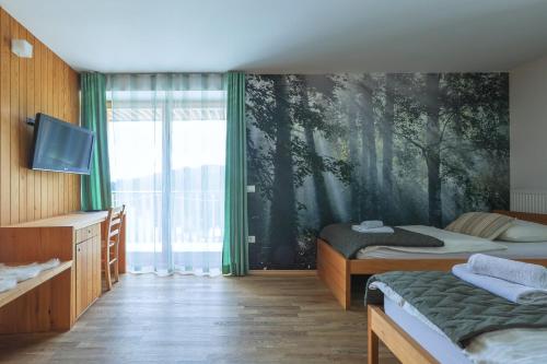 Podjelje伯祖卡耶尔卡酒店的一间卧室设有两张床,并拥有一幅树木壁画