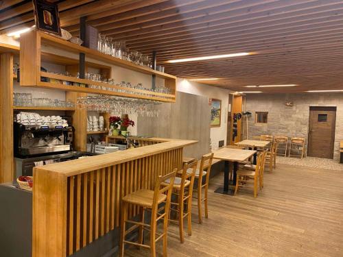 Podjelje伯祖卡耶尔卡酒店的餐厅设有酒吧,配有木桌和椅子