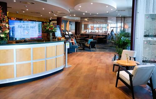 卡迪夫加的夫湾未来旅馆的餐厅设有酒吧和桌椅