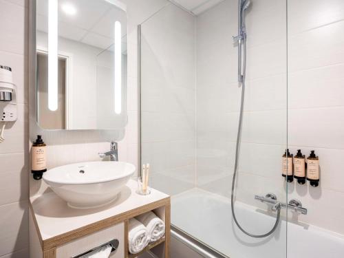 奥斯坦德奥斯坦德美居酒店的白色的浴室设有水槽和淋浴。