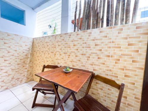 莫罗圣保罗Pousada Sol e Mar的砖墙前的一张木桌和两把椅子