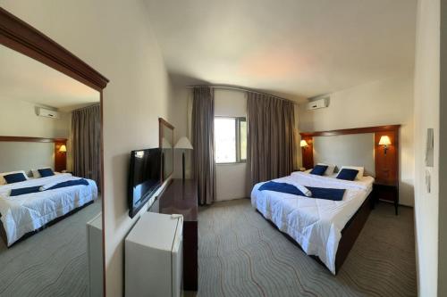 安曼Pasha Boutique Hotel的酒店客房设有两张床和一台平面电视。