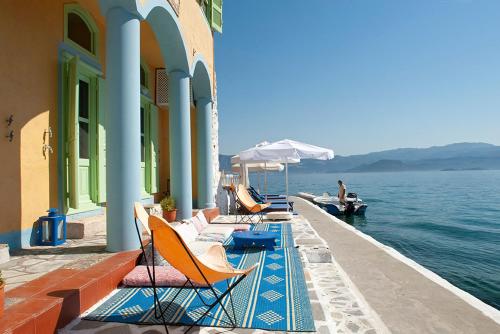 迈伊斯蒂Mediterraneo Hotel的码头上一排椅子和遮阳伞