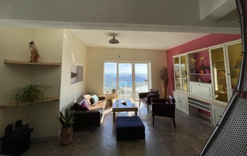 SellíaArt and Nature Apartment的带沙发和椅子的客厅以及大窗户。