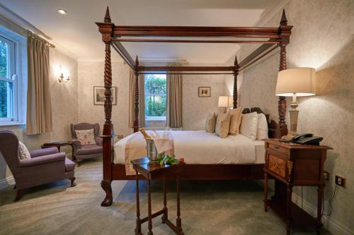 班特里海景小屋酒店的一间卧室配有一张大天蓬床和一把椅子