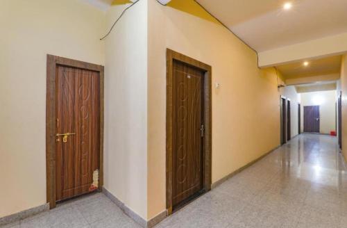 坎普尔Gsv hotel的走廊设有两扇棕色的门,铺有瓷砖地板
