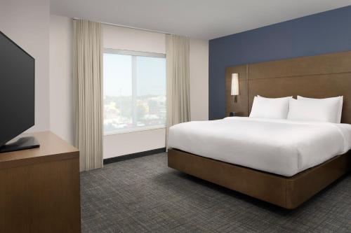 拉伯克Residence Inn by Marriott Lubbock-University Area的一间卧室设有一张大床和一个大窗户
