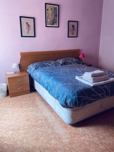 AlgaidaCompleta y Amplia Habitación a 10 minutos de la playa Casa Compartida的一间卧室配有一张带蓝色棉被的床