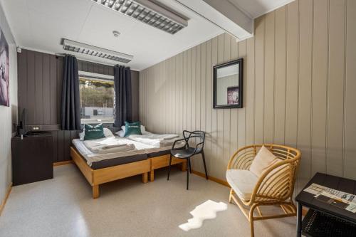 阿伦达尔Fengselshotellet AS的一间卧室配有一张床、一把椅子和一张书桌