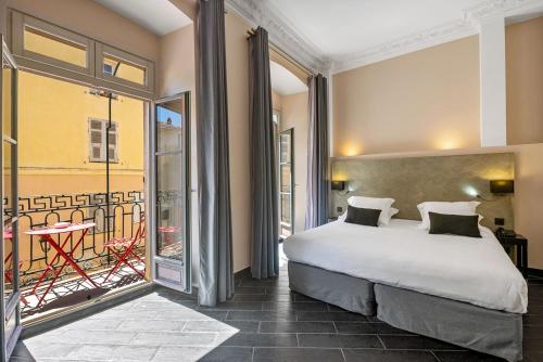 阿雅克修Hotel POZZO DI BORGO的一间带大床的卧室和一个阳台