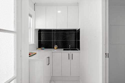 奥克兰Auckland airport holiday home的白色的厨房设有水槽和窗户