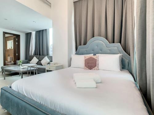 迪拜Key View - Hilliana Tower的一间卧室配有一张大床和蓝色床头板