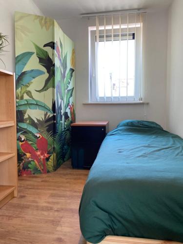 泽尔扎特Woning met 4 slaapkamers的一间卧室设有一张绿色的床和一个窗户。