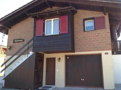 瑟伦贝格Fortuna的一座带红色百叶窗和车库的房子