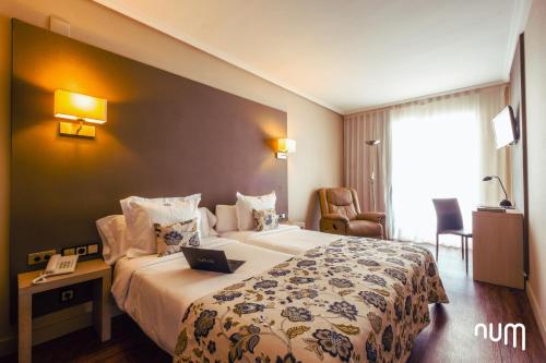 萨洛Num Hotel的酒店客房设有一张大床和电话