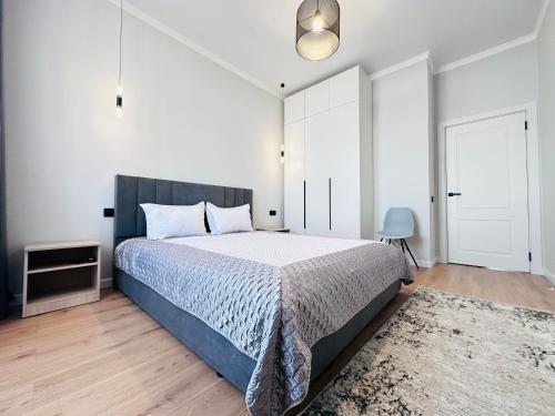 阿斯塔纳ЖК "Бухар жырау эксклюзив" Люксовые апартаменты的一间卧室配有一张带蓝色棉被的床
