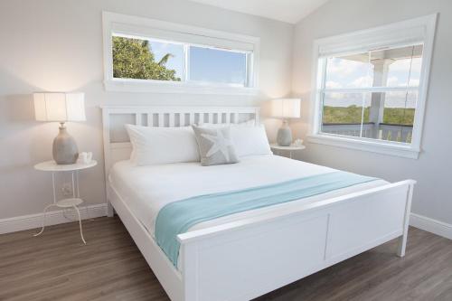 伊斯拉莫拉达Isla Mirabelle - Waterfront Boutique Resort, Island Paradise, Prime Location的白色卧室设有白色的床和2个窗户