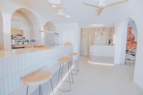 圣安东尼奥湾伊维萨岛日落绿洲公寓-只限成人的白色的厨房,配有两个凳子和一个柜台