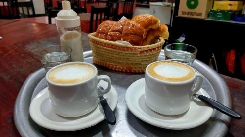 圣米格尔·德·图库玛拉斯卡雷塔斯旅馆的桌上的两杯咖啡和一篮糕点
