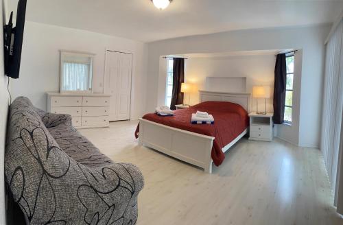 西罗通达Casa Del Mar, Full Refund, Poolheat, Sleeps 6的一间卧室配有红色的床和一张沙发
