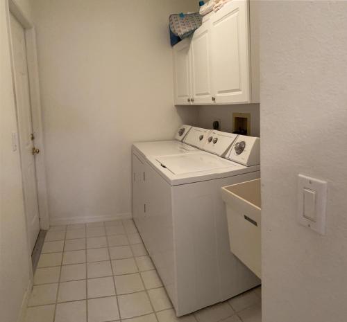 西罗通达Casa Del Mar, Full Refund, Poolheat, Sleeps 6的白色的小厨房,配有洗衣机和烘干机