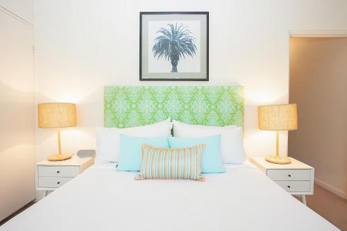 悉尼Bayside Tranquility的卧室配有带两盏灯的白色床