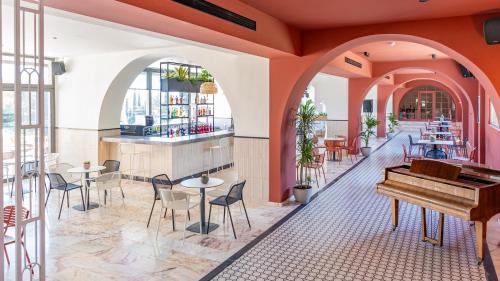 达西亚Iolida Corfu Resort & Spa by Smile Hotels的一间设有钢琴和桌椅的餐厅
