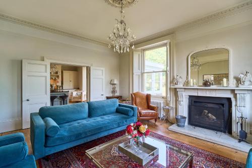 巴斯Berkeley House near Bath的客厅设有蓝色的沙发和壁炉