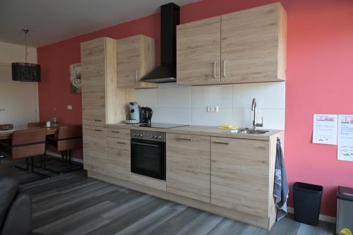 WichmondB&B gewoon Prins的厨房配有木制橱柜、水槽和桌子