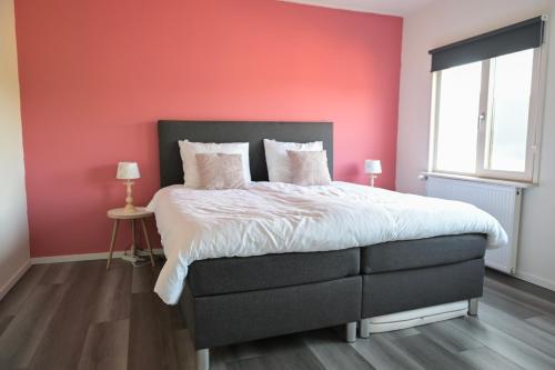 WichmondB&B gewoon Prins的卧室设有粉红色的墙壁和一张床