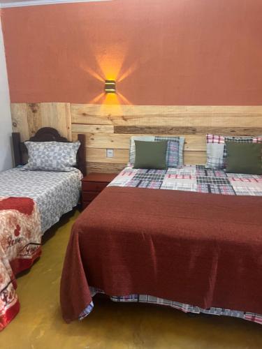 卡瓦坎特Pousada Recanto do Tucano的一间卧室配有两张床和一盏灯