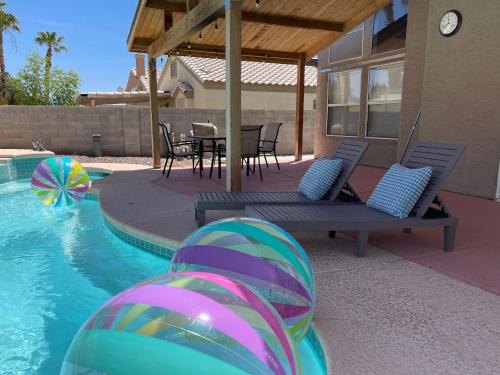 拉斯维加斯Pool House Newly Remodeled 3bed 3bath Near DT Summerlin and Red Rock的一个带桌椅的游泳池,一个水中球
