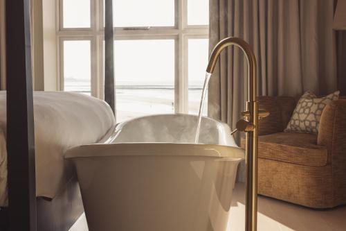 马盖特No 42 by GuestHouse, Margate的卧室设有浴缸、床和窗户
