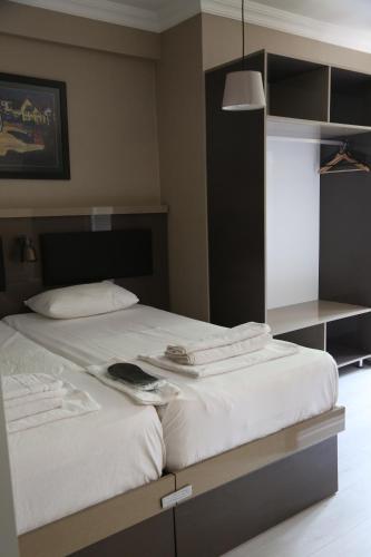 埃杰阿巴德Maidos suites的一间卧室配有一张带白色床单的大床