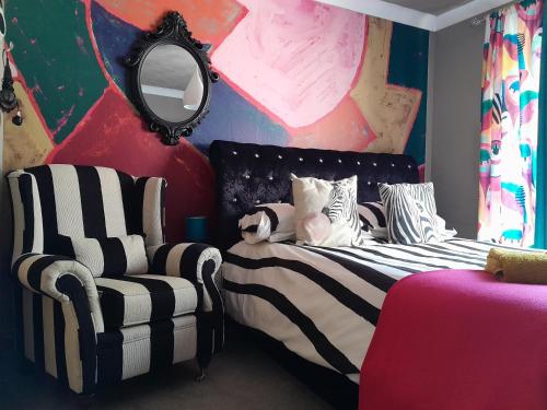 卡比斯贝Sailaway的一间卧室配有一张床、一把椅子和镜子