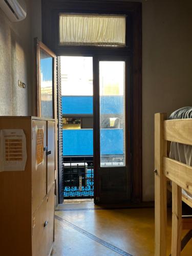 布宜诺斯艾利斯Parla Hostel的带门的房间,享有卧室的景色