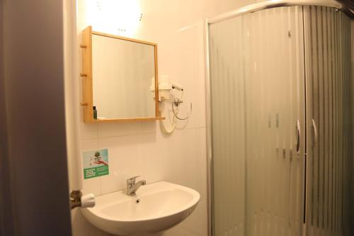 埃杰阿巴德Maidos suites的一间带水槽、镜子和淋浴的浴室