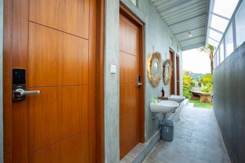 金塔马尼The Dewi Kintamani Luxury Glamping and Natural Hotspring的浴室设有门、卫生间和水槽。