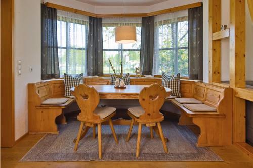 阿默湖畔乌廷Ferienhaus am Mühlbach Ammersee的一间带木桌和椅子的用餐室