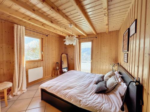 热拉梅Chalet de standing 14 personnes的卧室配有一张床铺,位于带木墙的房间内