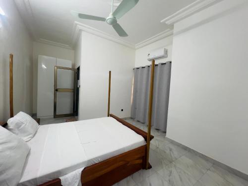 科托努Luxe Club的一间白色卧室,配有床和天花板