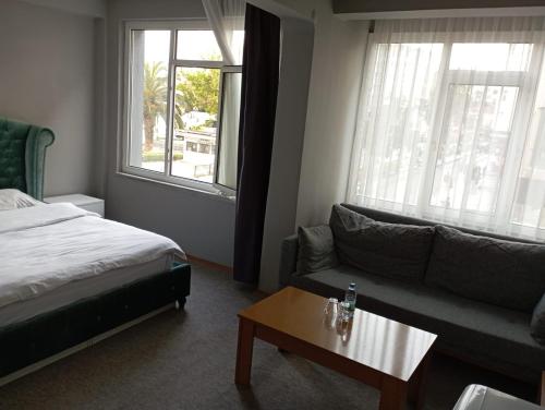 萨姆松Samsun Otel Vidinli的一间卧室配有一张床、一张沙发和一张桌子