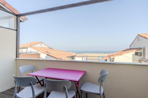 卡布勒通Atlantic Selection - Vue Océan avec terrasse, plage Notre-Dame的阳台配有粉红色的桌椅